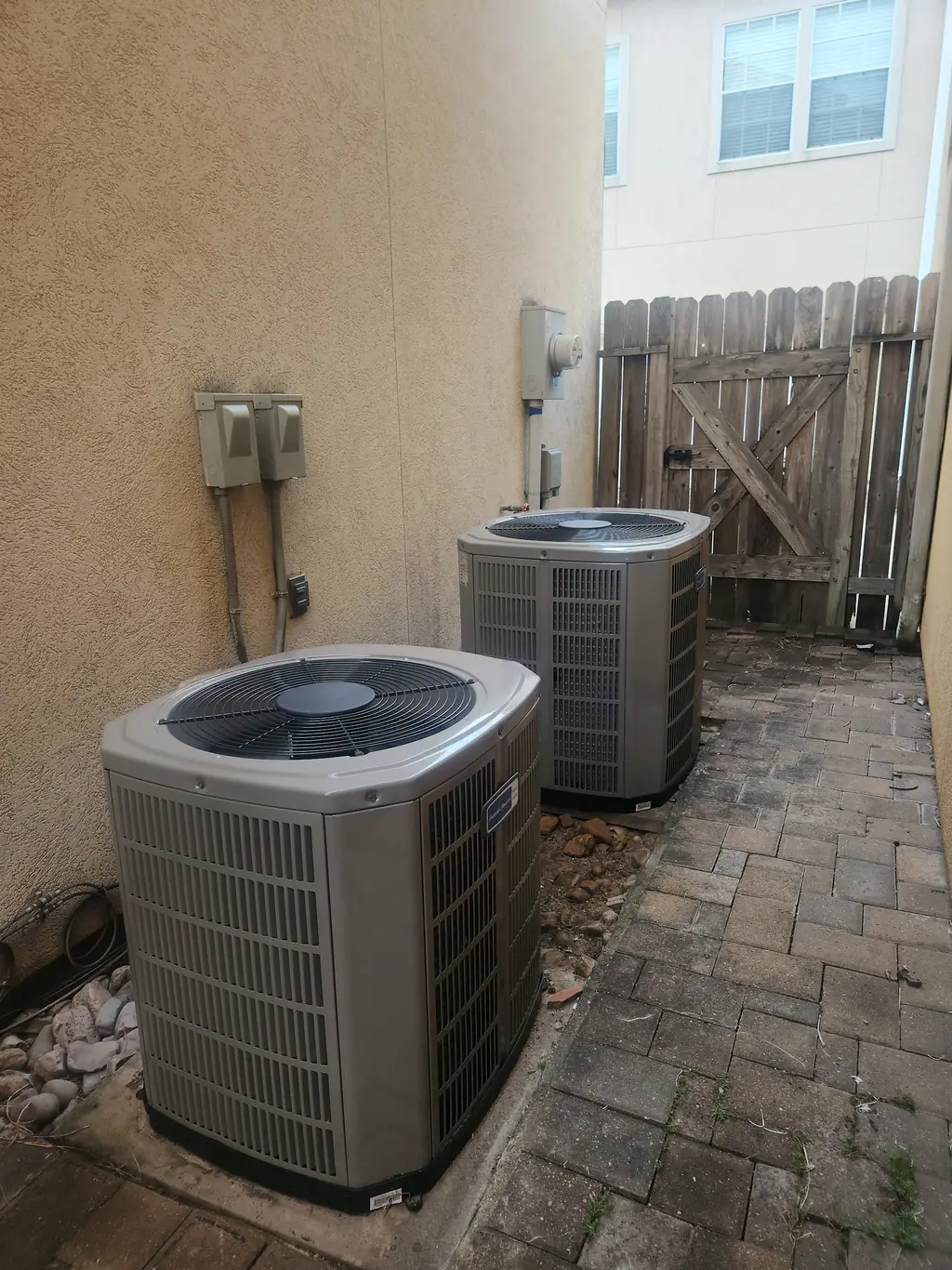 Two American Standard condensers on a pad with line sets and disconnects neatly run
